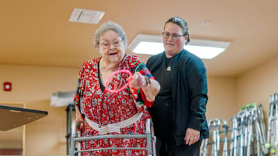 Resident participating in an activity with staff support