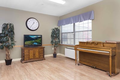 Bright common area with a piano and TV