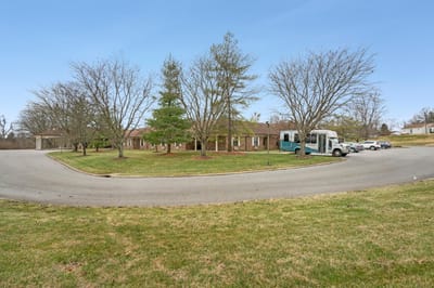 Exterior view of a senior living facility with trees and parking