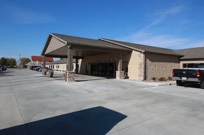 Front entrance of a senior living facility with parking
