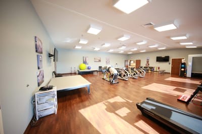 Bright activity room with exercise equipment and open space