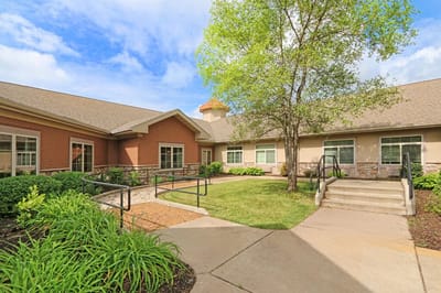 Exterior view of a senior living facility with gardens