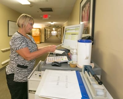 Staff member organizing materials in a hallway
