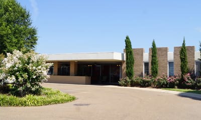 Exterior view of the assisted living facility with landscaped entrance