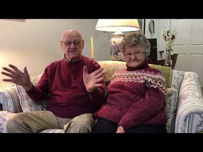 A senior couple sitting together on a sofa