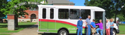 A group of residents by the facility van outside