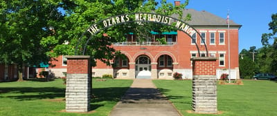 Front view of a senior living facility with greenery