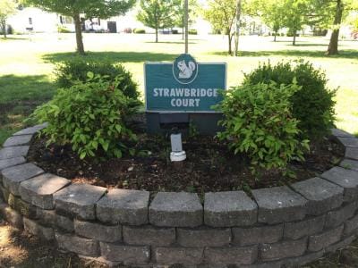 Sign for Strawbridge Court surrounded by greenery