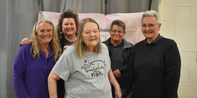 Residents and staff smiling together at a celebration
