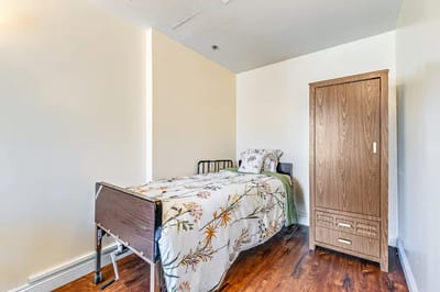 Private bedroom in a senior living facility with floral blanket