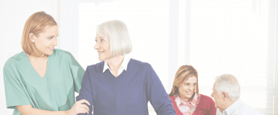 Arbor Care Centers – Ord, LLC, Nursing Home in Ord, NE — Caregiver assisting a senior woman in a bright room