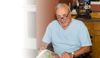 Senior male resident reading a newspaper indoors