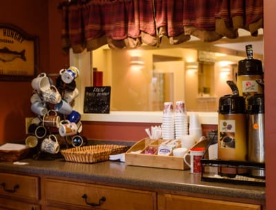 Coffee station with mugs and snacks in the facility