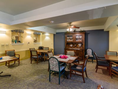 Common area with tables and chairs in a senior living facility