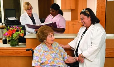 Staff assisting a resident in a welcoming reception area