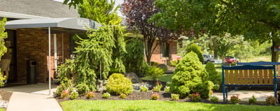 Lush gardens and seating area in front of facility