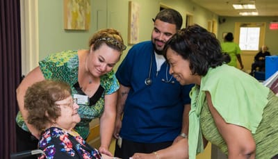 Staff interacting with a resident in a corridor