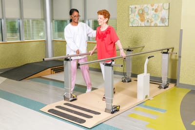 Staff assisting a resident with walking exercises