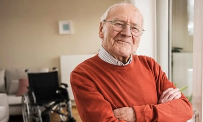 An elderly man smiling in a cozy living room