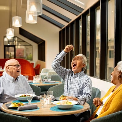 Residents enjoying a meal together in the dining room