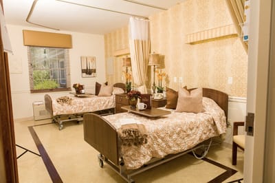 Well-decorated resident bedroom with two beds and flowers