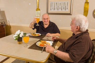 Two residents enjoying a meal together in the dining room