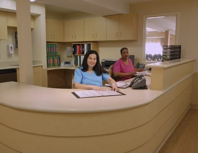 Reception area with two staff members at the front desk