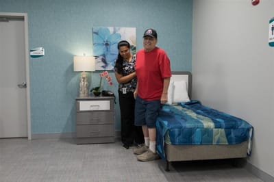 Staff assisting a resident in a decorated room