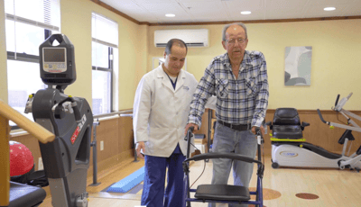 Therapist assisting a resident in a physical therapy session