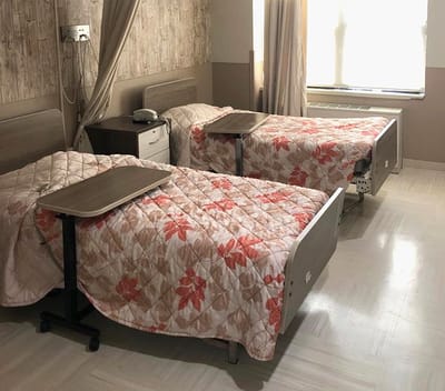 Private resident room with two beds and floral bedding