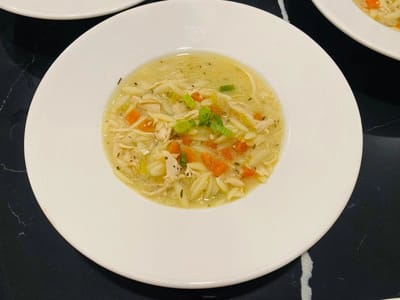 A bowl of chicken soup with vegetables