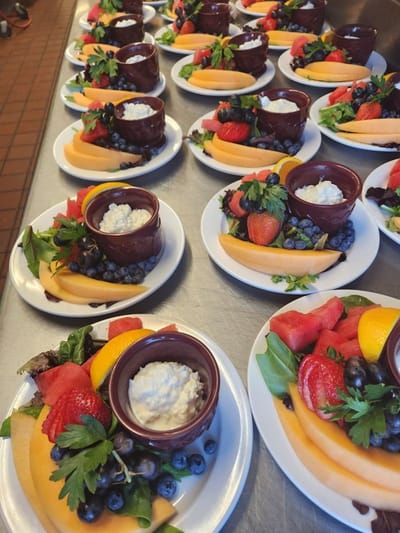 Plates of colorful fruit and cottage cheese served