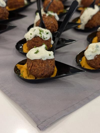 Gourmet meatballs served on black plates with sauce