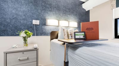 Cozy resident room with a bedside table and flowers