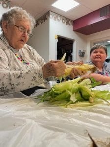Midwest Covenant Home, Nursing Home in Stromsburg, NE — Seniors preparing corn together in an activity space