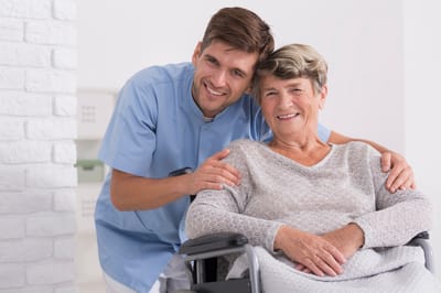 Caregiver with a resident in a facility setting.