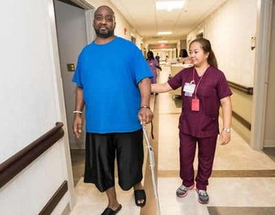 Staff assisting a resident in a hallway