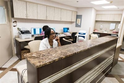 Staff member assisting at the reception desk in the facility