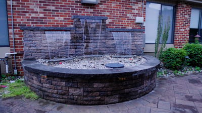A decorative outdoor water fountain surrounded by plants