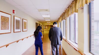 Staff assisting resident in a hallway