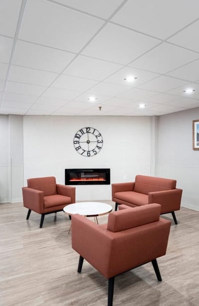 Modern lounge area with seating and a clock