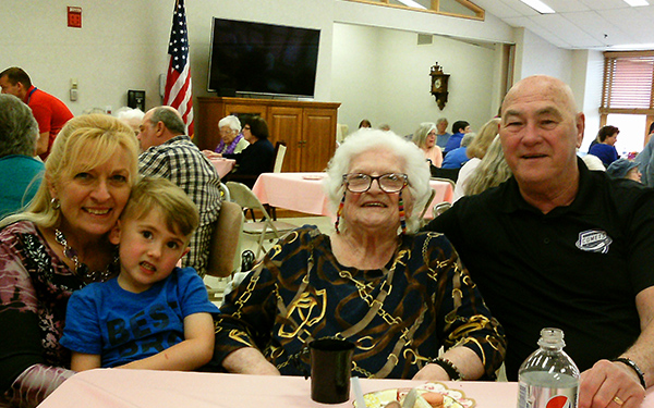Family members enjoying a meal with a senior resident