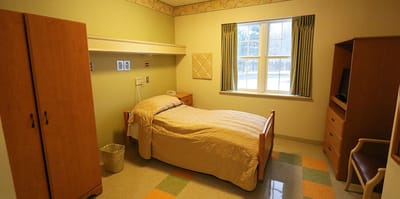 A private room with a bed and furnishings