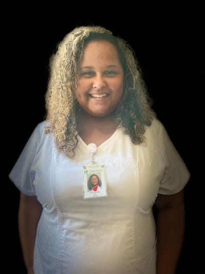 Staff member with ID badge smiling for the camera