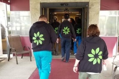Staff wearing branded hoodies exiting a facility