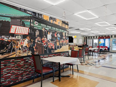 Bright dining room with mural and tables for residents