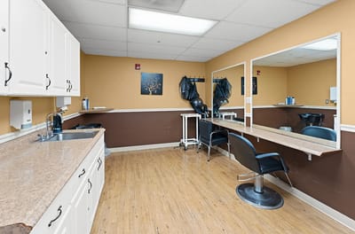 A salon area with chairs and mirrors
