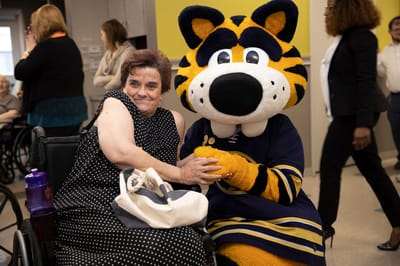 Resident enjoying an event with a mascot character