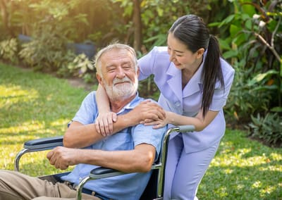 Sunnyside Care Center, Nursing Home in East Syracuse, NY — Smiling elderly man in a wheelchair with caregiver outdoors