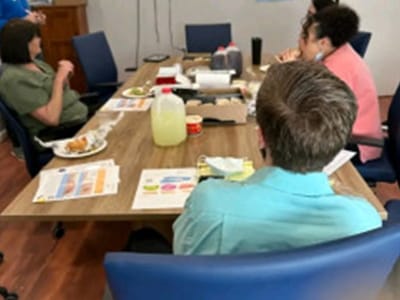 Residents and staff gathered around a table during a meeting